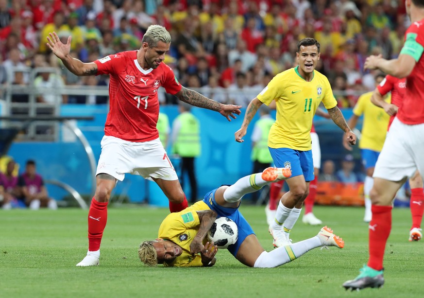 epa06816801 Neymar of Brazil (down) and Valon Behrami of Switzerland (L) in action during the FIFA World Cup 2018 group E preliminary round soccer match between Brazil and Switzerland in Rostov-On-Don ...