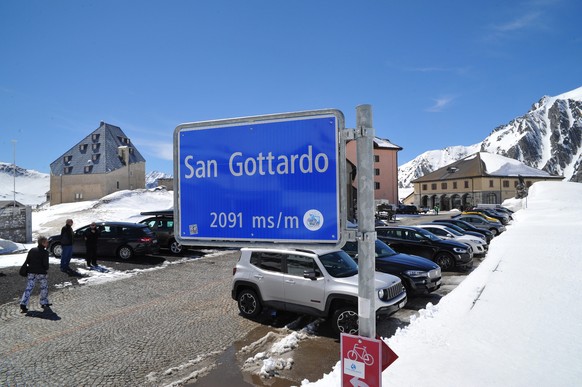 epa05318853 Tourists walking next to snow masses on the Gotthard pass, in Airolo, Switzerland, 20 May 2016. The Gotthard pass has been officialy reopened on 20 May 2016. EPA/BENDETTO GALLI