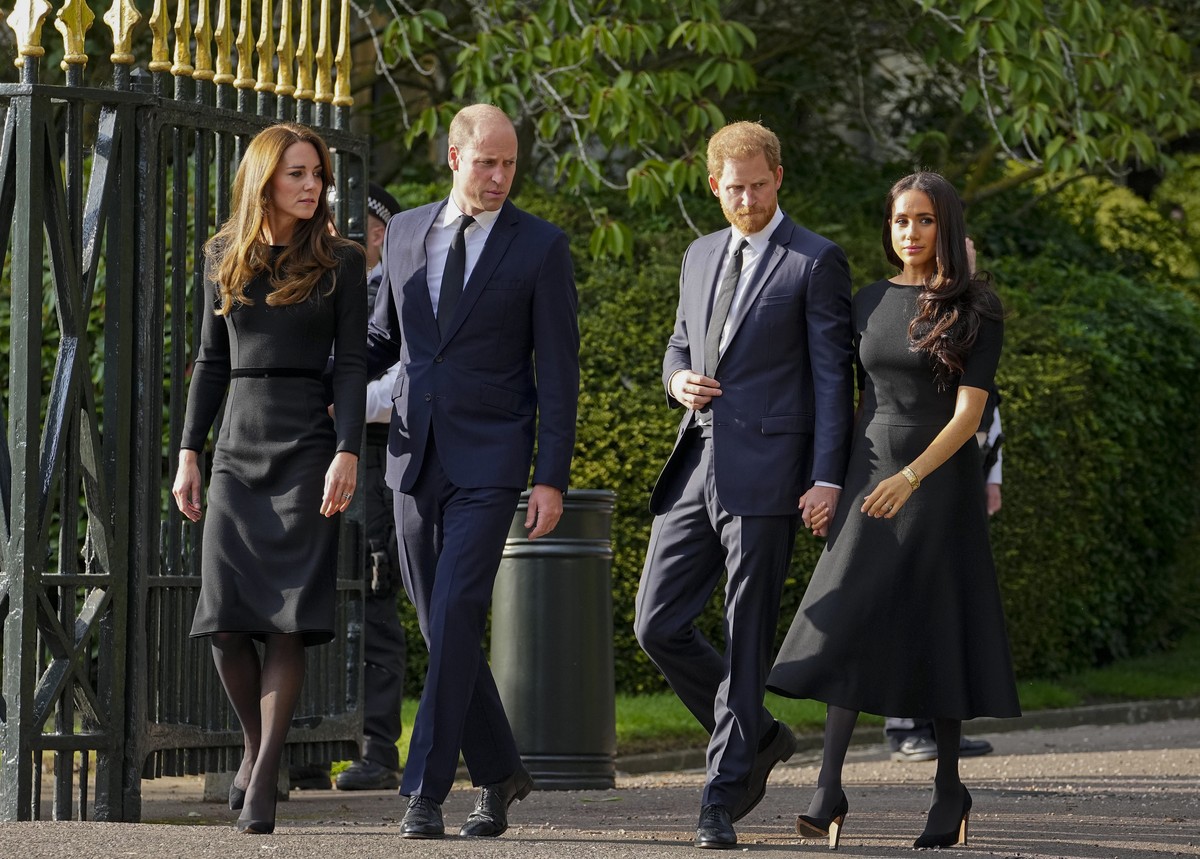 Britain's Prince William, second left, Kate, Princess of Wales, left, Britain's Prince Harry, second right, and Meghan, Duchess of Sussex view the floral tributes for the late Queen Elizabet ...