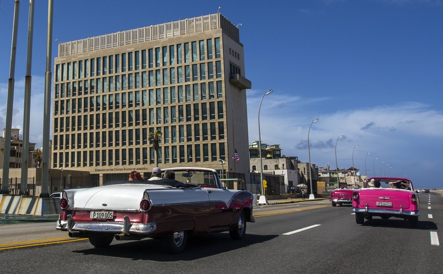 FILE - In this Oct. 3, 2017, file photo, tourists ride classic convertible cars on the Malecon beside the United States Embassy in Havana, Cuba. The Biden administration faces increasing pressure to r ...