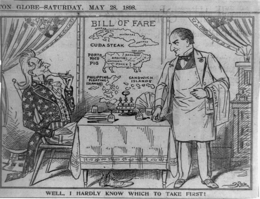 Uncle Sam, bedient von Präsident McKinley, schaut sich im Restaurant das Menü der spanischen Kolonien an: «Nun, ich weiss gar nicht, was ich zuerst nehmen soll!»