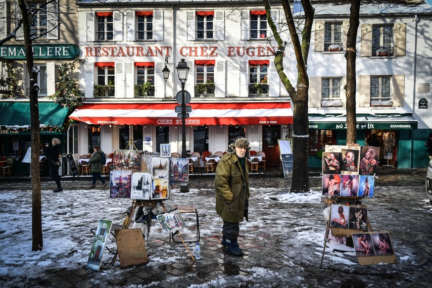 Streets Of Paris Covered With A Snow Blanket An artist poses with his paintings in the Montmartre neighborhood in Paris as snow covers the city on January 18, 2024. Photo by Firas Abdullah/ABACAPRESS. ...