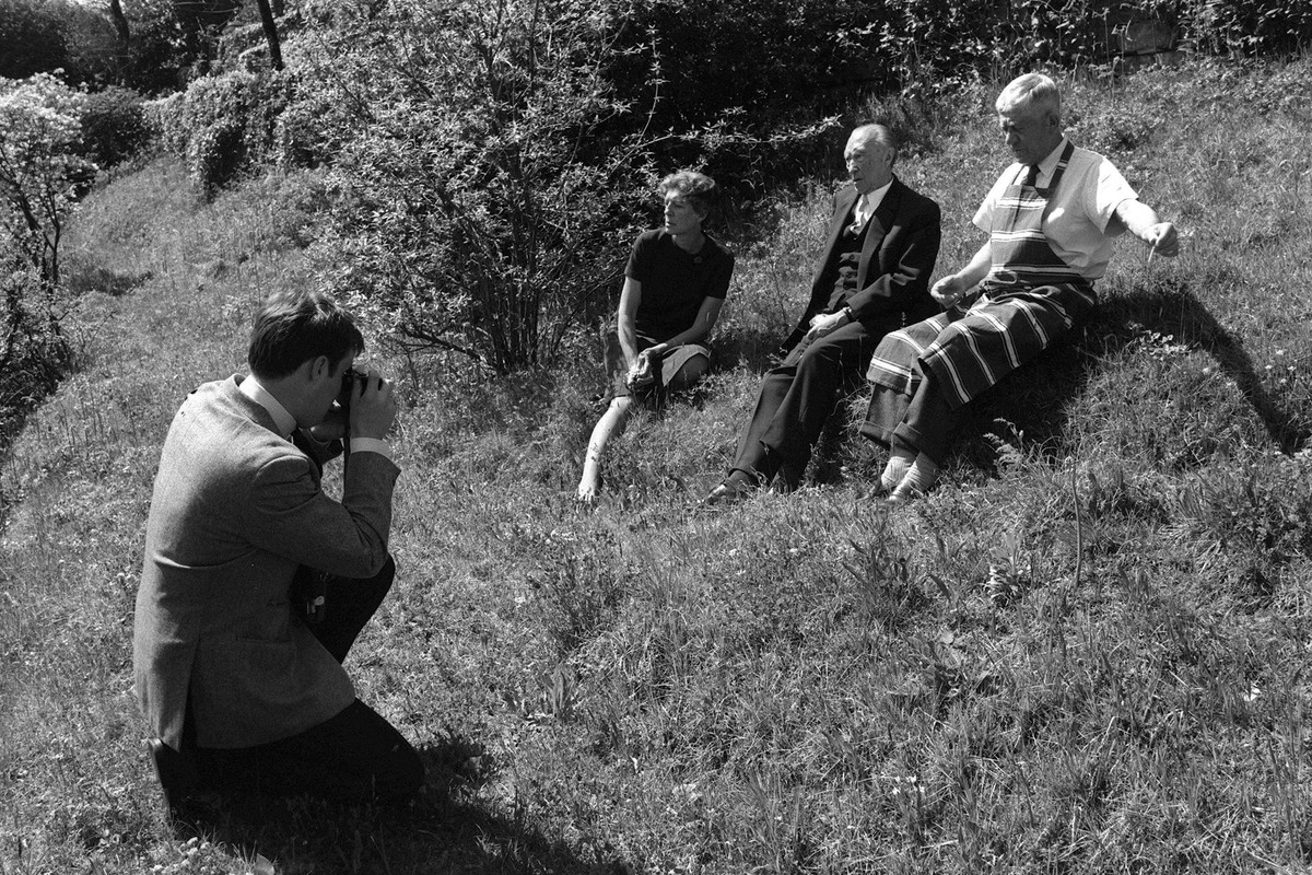 Konrad Adenauer GER/CDU/Bundeskanzler a.D. sitzt zwischen dem Maler Oskar Kokoschka AUT und dessen Ehefrau Olda AUT auf einer Wiese, fotografiert von Axel Springer Jr. - Cadenabbia