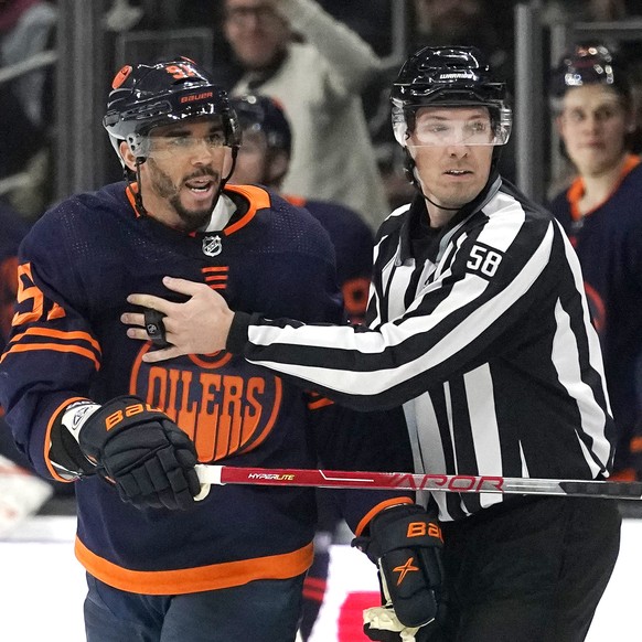 Edmonton Oilers left wing Evander Kane, left, is taken to the penalty box by linesman Ryan Gibbons after he punched Los Angeles Kings left wing Brendan Lemieux during the second period of an NHL hocke ...