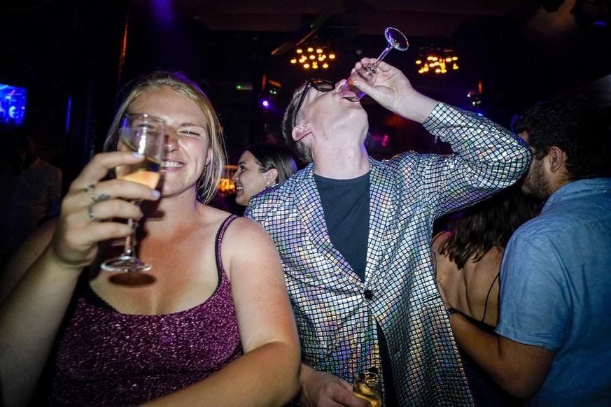 People drink on the dance floor shortly after the reopening, at The Piano Works in Farringdon, in London, Monday, July 19, 2021. Thousands of young people plan to dance the night away at &#039;Freedom ...