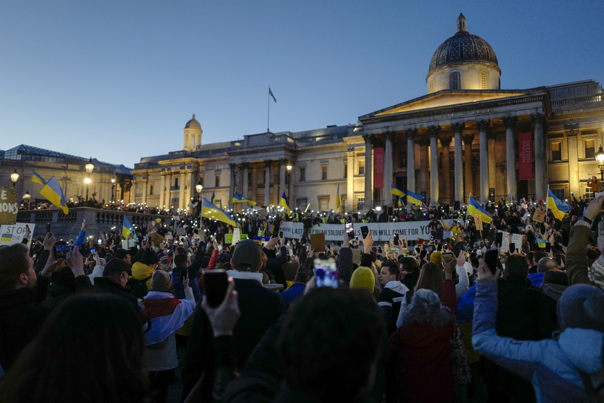 Demonstrators hold placards and Ukraine flags during a protest in Trafalgar Square in London, Sunday, Feb. 27, 2022. A Ukrainian official says street fighting has broken out in Ukraine's second-l ...