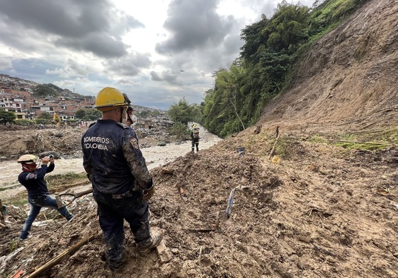 epa09739633 Lifeguards look for victims of a mudslide caused by heavy rains in Pereira, Colombia, 08 February 2022. At least 14 people, three of them thought to be young boys, have been killed and 35  ...