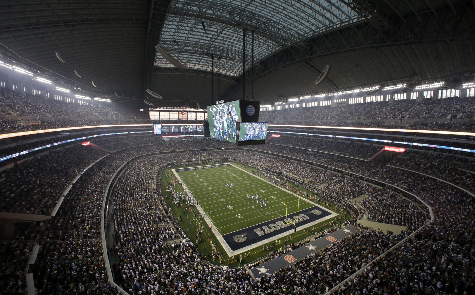 FILE - Fans watch at the start of an NFL football game inside AT&amp;T Stadium between the New York Giants and Dallas Cowboys, Sunday, Sept. 8, 2013, in Arlington, Texas. There are 23 venues bidding t ...