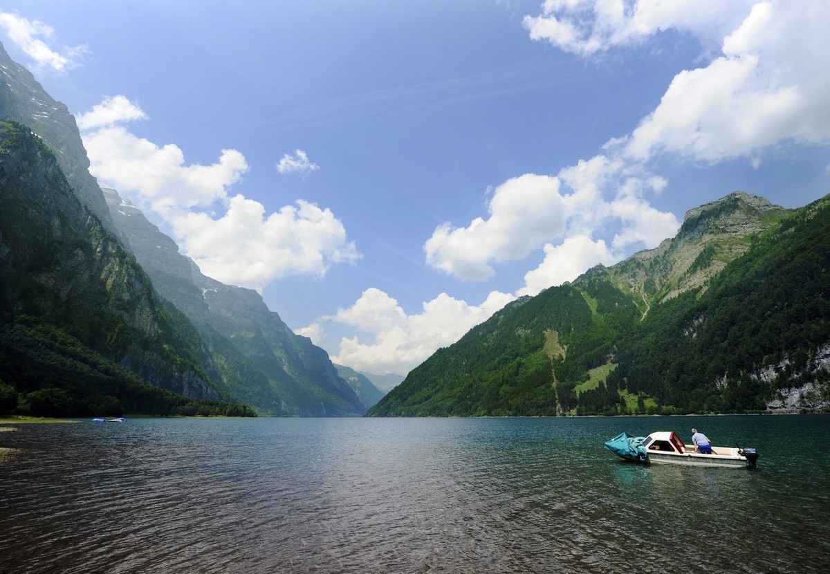 Ein Angler geniesst das herrliche Sommerwetter auf dem Kloentaler See im Kanton Glarus am Mittwoch, 30. Juni 2010. (KEYSTONE/Steffen Schmidt)