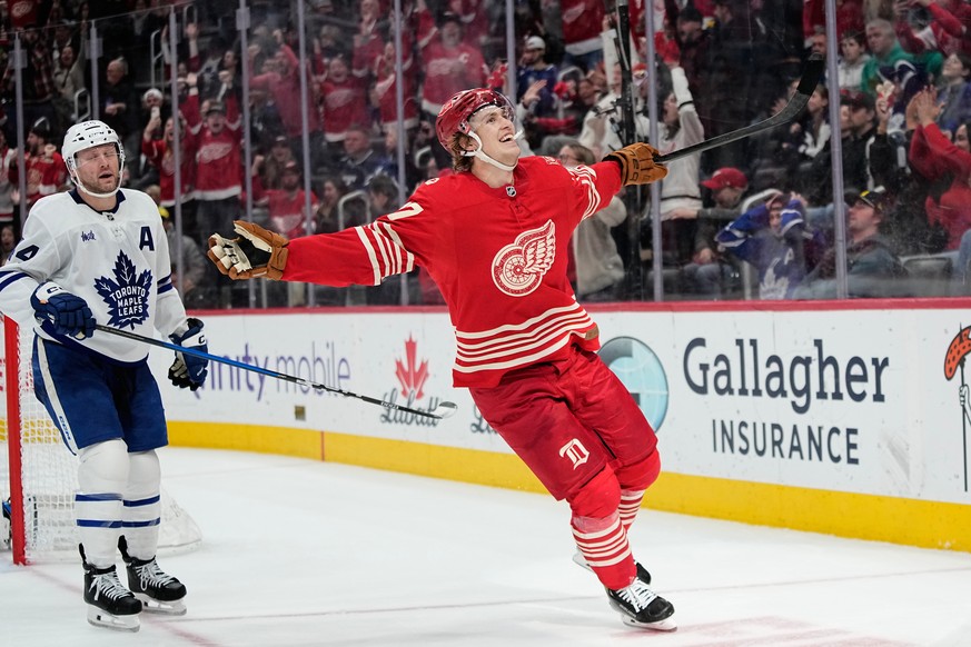 FILE - Detroit Red Wings defenseman Simon Edvinsson, right, celebrates near Toronto Maple Leafs defenseman Morgan Rielly, left, after scoring the winning goal during overtime of an NHL hockey game, De ...