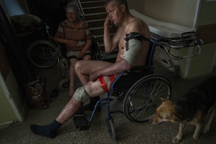 FILE - A Ukrainian injured serviceman and an injured civilian wait for medical treatment in the Donetsk region, eastern Ukraine, Tuesday, June 7, 2022. Ukraine's Defense Minister Hanna Malyar sai ...