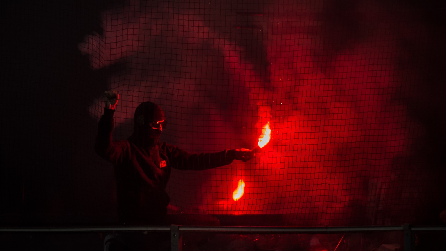 A fan of Lausanne with a flare during the preliminary round game of the National League between HC Ambri-Piotta and Lausanne HC, at the ice stadium Valascia in Ambri, on Sunday, January 14, 2018. (KEY ...