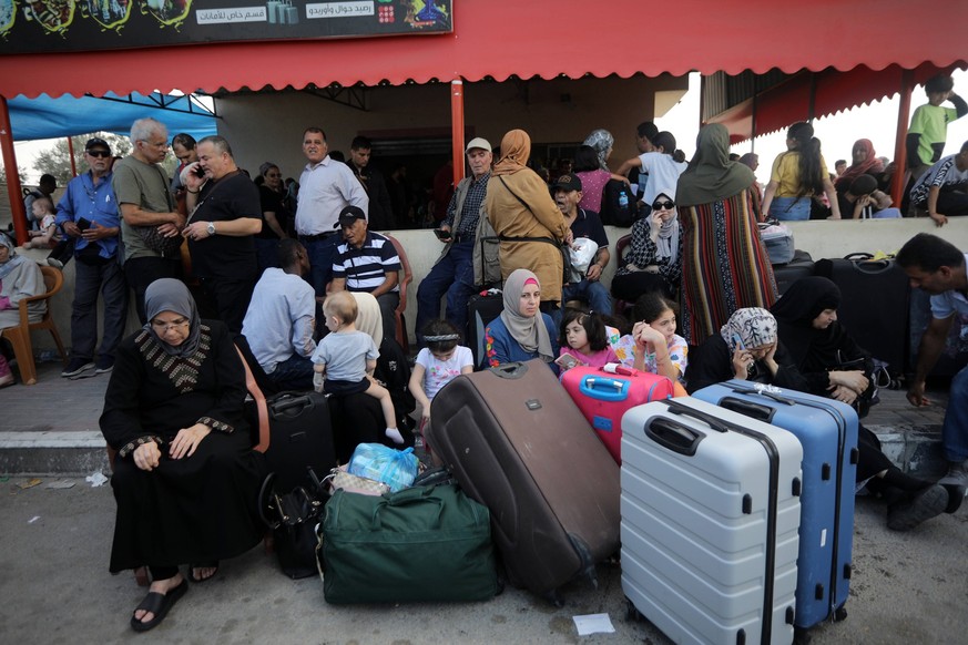 People carrying foreign passports wait at the Rafah gate hoping to cross into Egypt as Israel s attacks on the Gaza Strip continues, Saturday October 14, 2023.. International aid groups and major powe ...