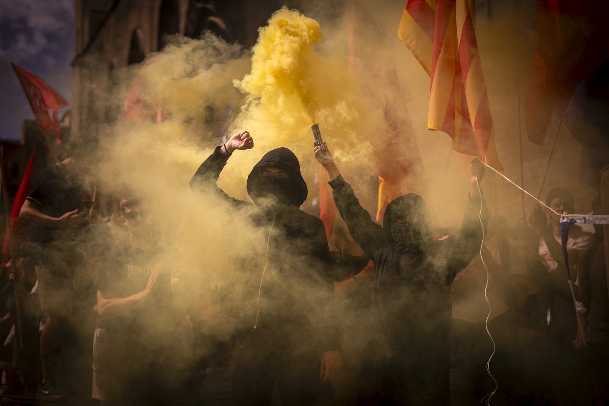 Left-wing pro-independence demonstrators burn a Spanish and French flag, partly seen at right, as they shout slogans calling for Catalonia's independence from Spain, during the Catalan National D ...