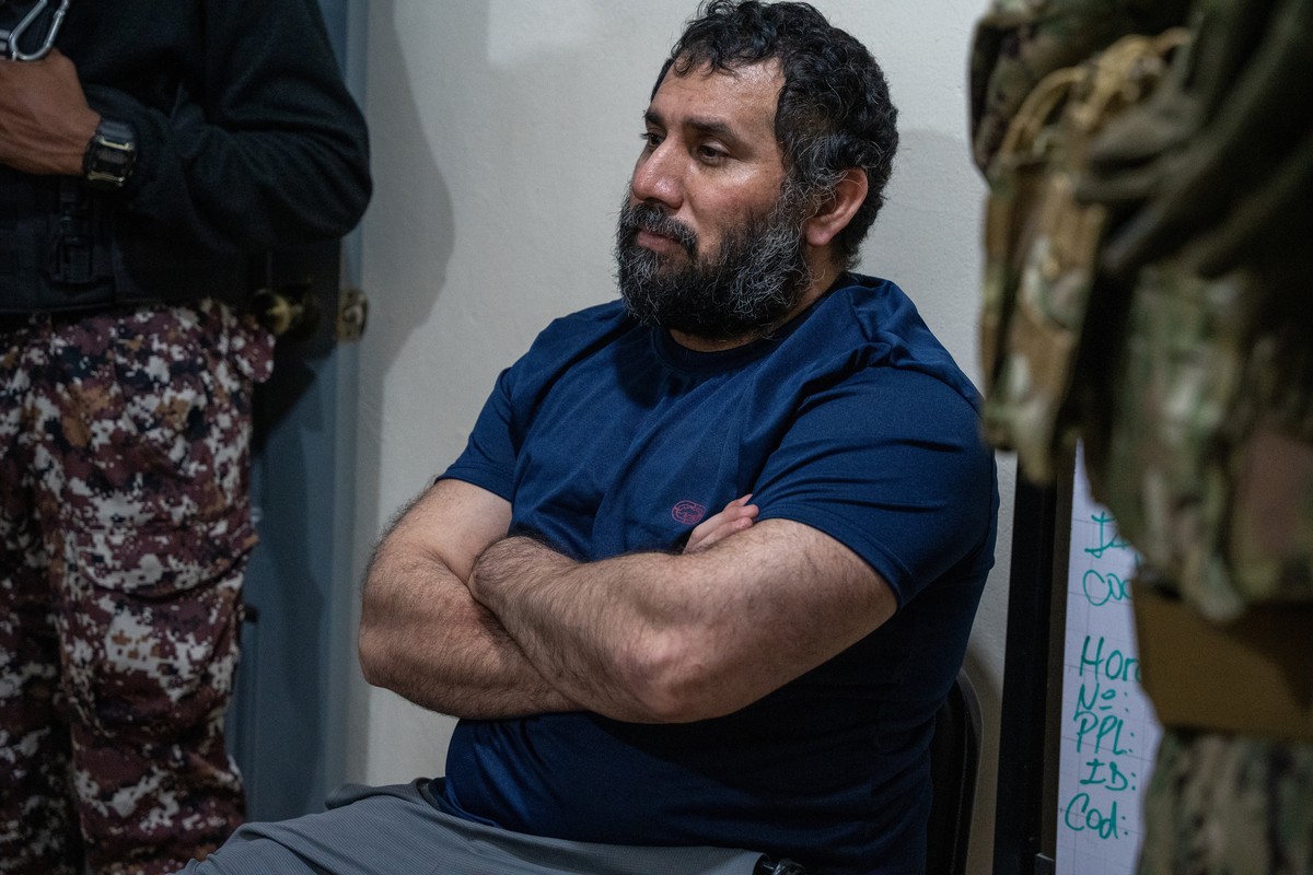 epa12198535 Drug trafficker Jose Adolfo Macias Villamar 'Fito' (C) is guarded upon arrival at La Roca prison in Guayaquil, Ecuador, 25 June 2025. 'Fito' arrived at the Guayaquil Ai ...