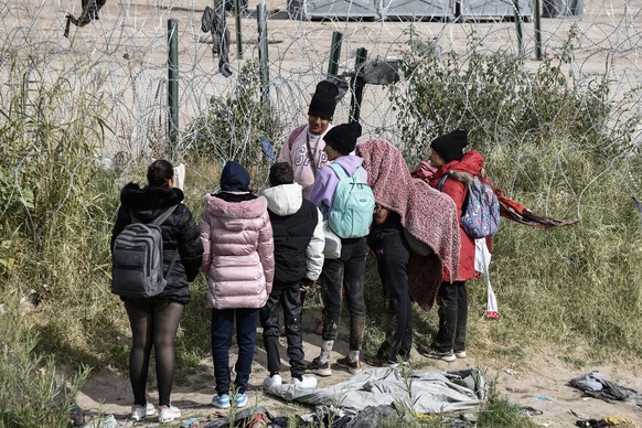 epa11004196 Migrants gather beside a razor wire fence, as they prepare to spend the night near the US-Mexico border wall in Ciudad Juarez, in the state of Chihuahua, Mexico, 30 November 2023. The firs ...