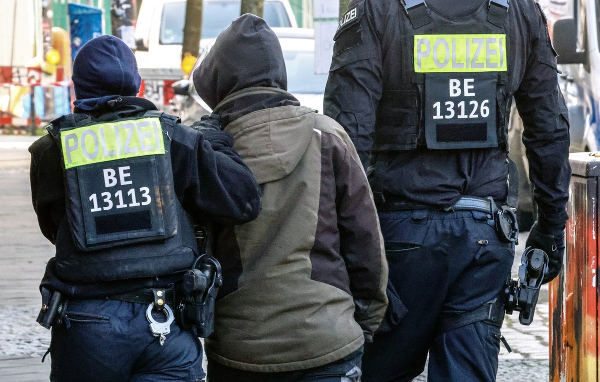 epa11196011 Members of a special police unit escort a person during a search operation for long-sought former members of Germany's Red Army Faction (RAF) militant group, Ernst Volker Staub and Bu ...