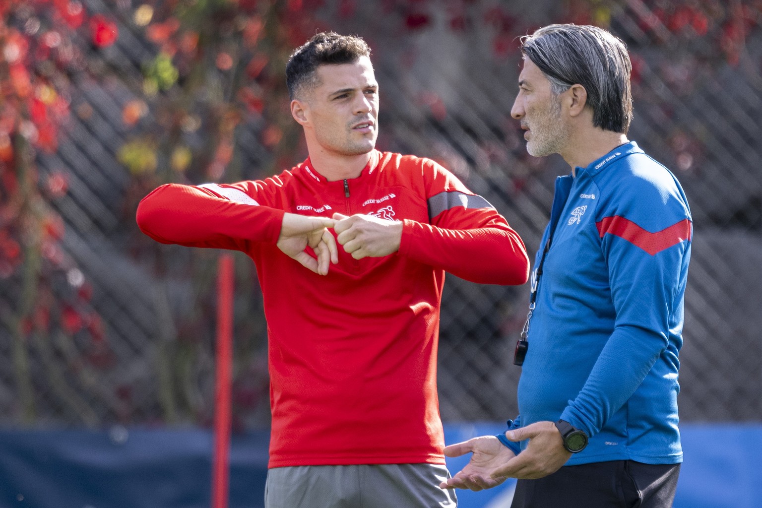 epa10914617 Swiss national soccer team head coach Murat Yakin speaks with his player Granit Xhaka during a training session in St. Gallen, Switzerland, 12 October 2023. Switzerland will face Belarus o ...