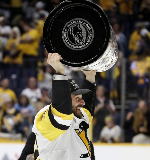 Pittsburgh Penguins defenseman Mark Streit, of Switzerland, celebrates with the Stanley Cup after the Penguins defeated the Nashville Predators 2-0 in Game 6 of the NHL hockey Stanley Cup Finals Sunda ...