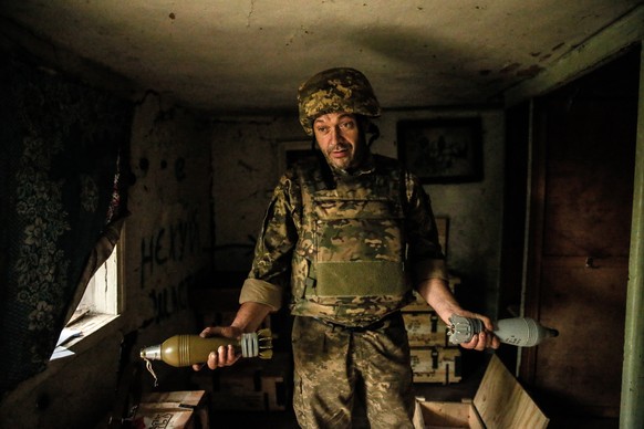 epa10758501 A Ukrainian serviceman of the 24 separate mechanized brigade named after King Danylo, holds mortar shells at a military positions in the Donetsk region, 20 July 2023. The war in Ukraine, w ...