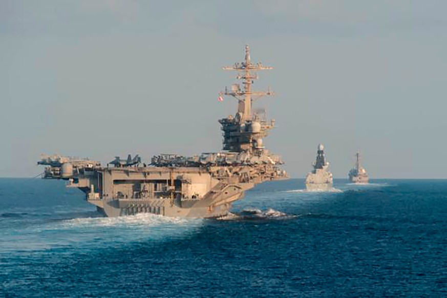 FILE - In this Nov. 19, 2019, photo made available by U.S. Navy, the aircraft carrier USS Abraham Lincoln, left, the air-defense destroyer HMS Defender and the guided-missile destroyer USS Farragut tr ...