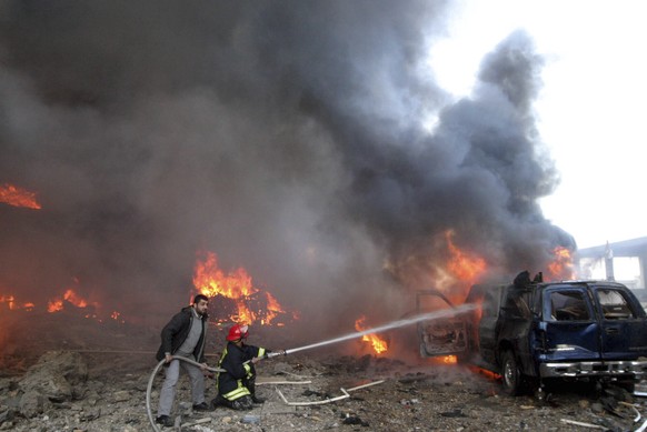 FILE - Rescue personnel hose down a burning vehicle after a bomb blast that targeted the covoy of Prime Minister Rafik Hariri in Beirut Monday, Feb.14 2005. Appeals judges at an international tribunal ...