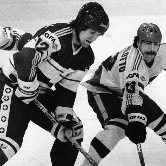 Der Schweizer Urs Baertschi, Mitte, kaempft am 30. Maerz 1985 gegen die italienischen Spieler Mastrullo, links, und Pasqualotto, rechts, um den Puck. Die Schweiz gewinnt das Spiel an der Eishockey B-W ...