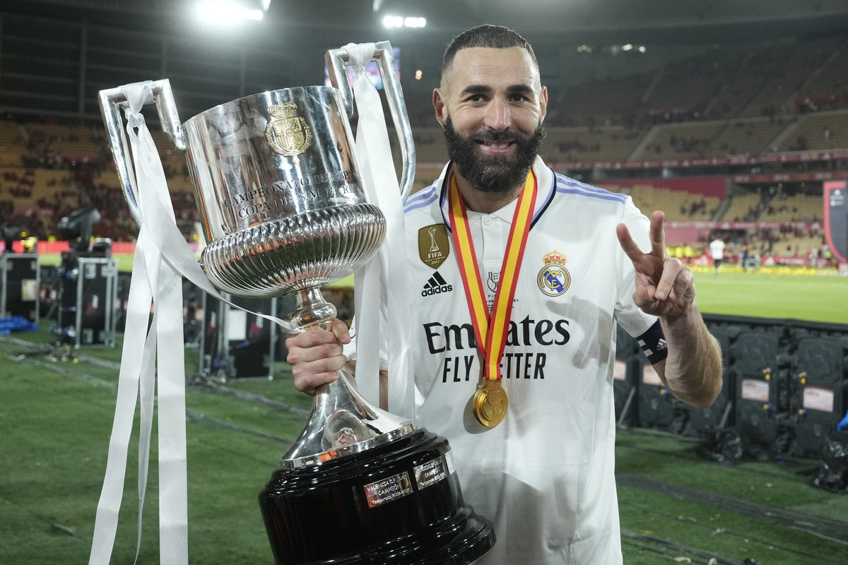 Real Madrid's Karim Benzema poses with the trophy after Madrid defeated Osasuna 2-1 in the Copa del Rey soccer final at La Cartuja stadium in Seville, Spain, Saturday, May 6, 2023. (AP Photo/Jose ...