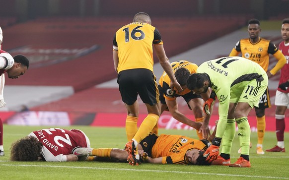 Players attend to Arsenal's David Luiz, left, and Wolverhampton Wanderers' Raul Jimenez following ahead clash during the English Premier League soccer match between Arsenal and Wolverhampton ...