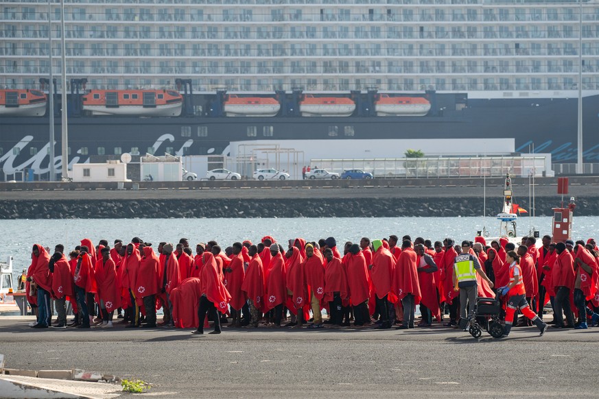 epa11796011 Red Cross members help some of the 240 migrants that have been rescued by Rescue Navy when they tried to reach the coast of Canary Islands by boats, at the docks in Arrecife, Lanzarote, Ca ...