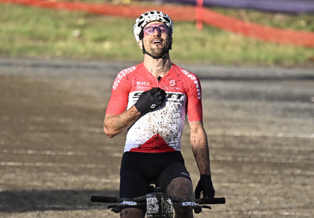 Nino Schurter, of Switzerland, touches his chest as he crosses the finish in 14th place, knowing he clinched UCI World Cup season trophy, at the men's elite class UCI mountain bike World Cup cros ...