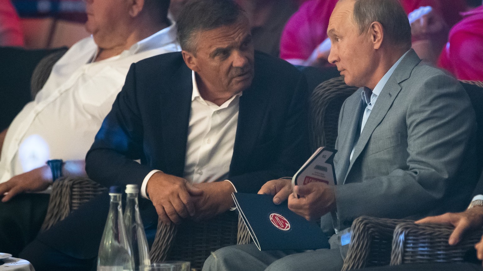 Russian President Vladimir Putin, right, and International Ice Hockey federation President Rene Fasel, left, talk to each other as they attend an international tournament in professional Sambo Plotfor ...