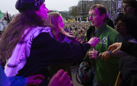 Climate activist Greta Thunberg, second left, is interrupted by a climate activist after Thunberg expressed solidarity with the Palestinians as tens of thousands of people marched through Amsterdam, N ...