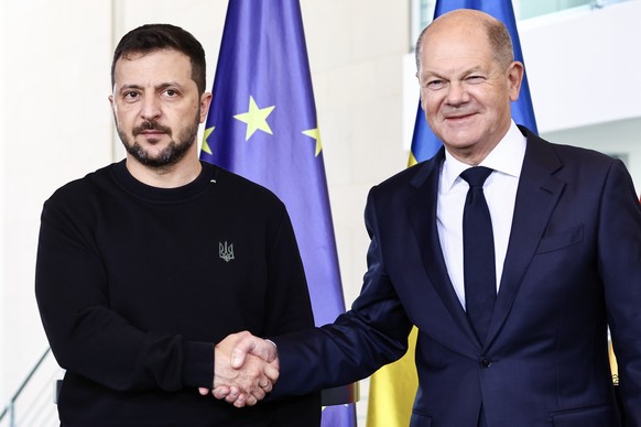 epa11654664 German Chancellor Olaf Scholz (R) shakes hands with Ukrainian President Volodymyr Zelensky as they pose for the media during their meeting at the Chancellery in Berlin, Germany, 11 October ...