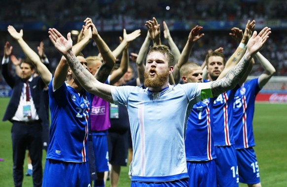 epa05395426 Aron Gunnarsson (front) of Iceland and his teammates celebrate after the UEFA EURO 2016 round of 16 match between England and Iceland at Stade de Nice in Nice, France, 27 June 2016. Icelan ...