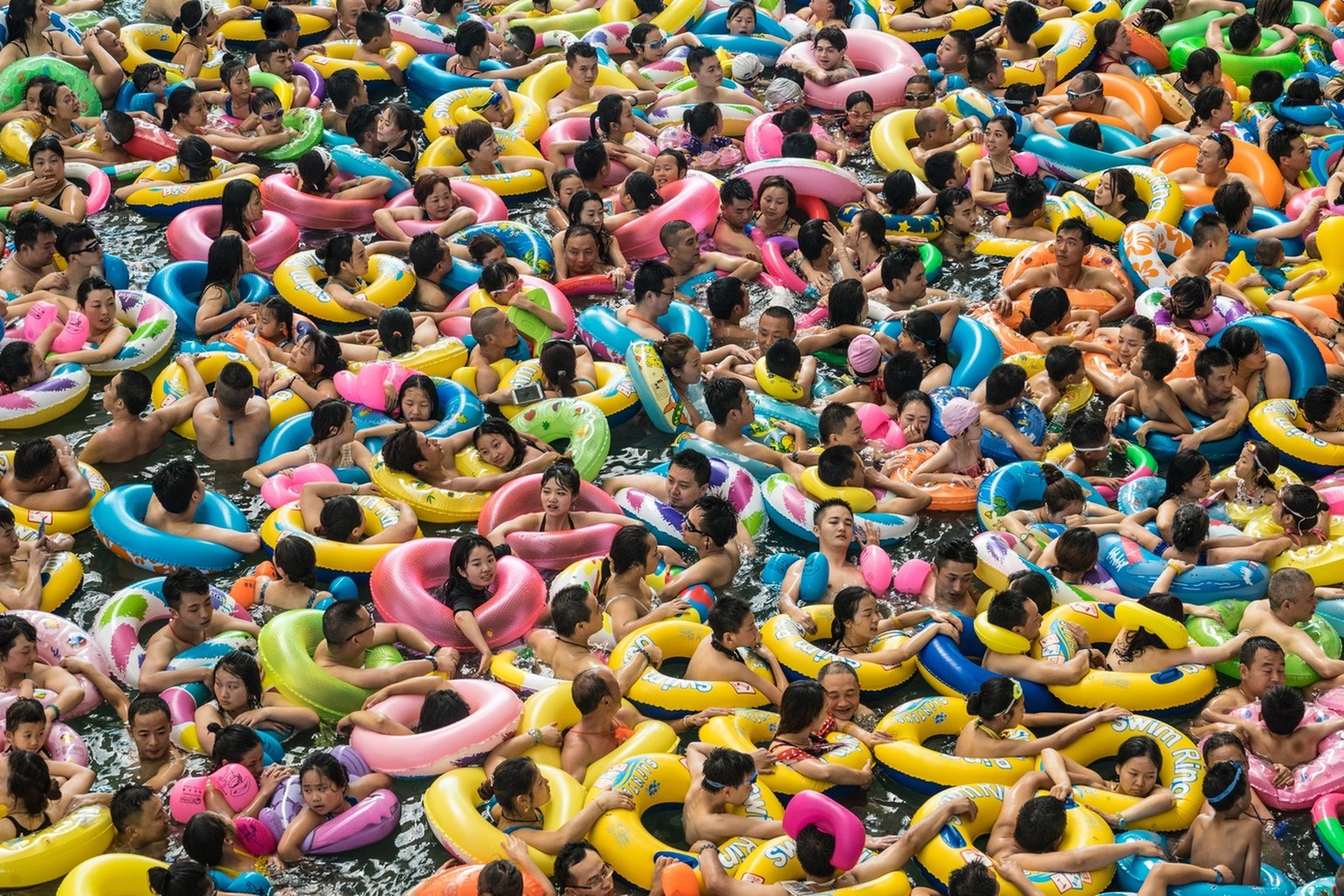 epa06260390 YEARENDER 2017 JULY..Chinese tourists with swim rings enjoy swimming in the lake called 'Dead sea of China' in a resort of Suining city, southwestern China's Sichuan provinc ...