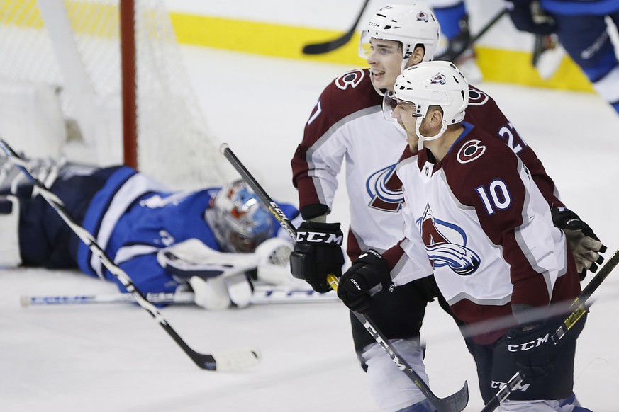 Colorado Avalanche&#039;s Ryan Graves (27) and Sven Andrighetto (10) celebrate Andrighetto&#039;s goal on Winnipeg Jets goaltender Connor Hellebuyck (37) during the third period of an NHL hockey game  ...