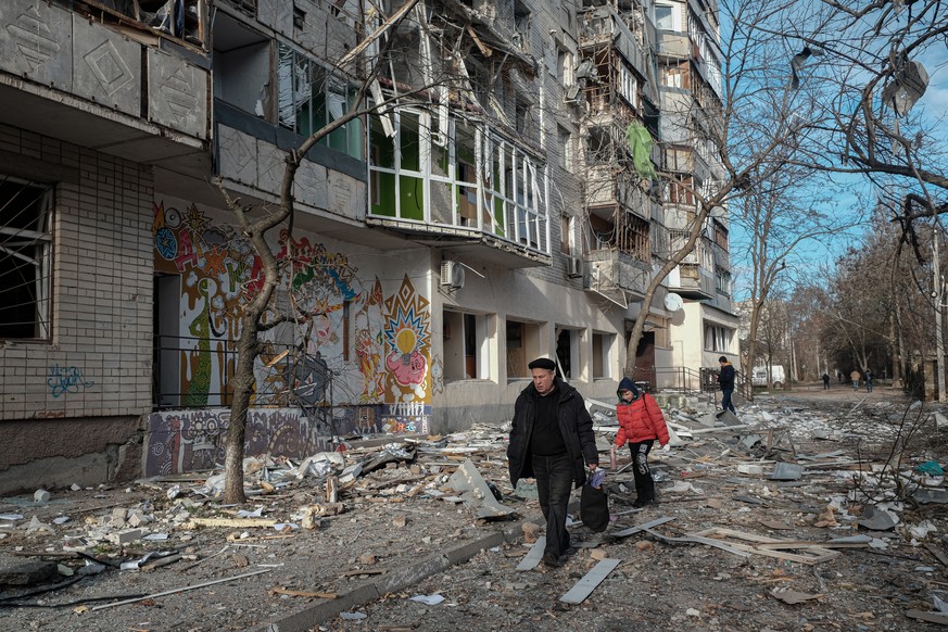 epaselect epa10375636 Residents pass a destroyed appartment building following overnight shelling in Kherson, Ukraine, 21 December 2022. Ukrainian troops entered Kherson on 11 November after the Russi ...