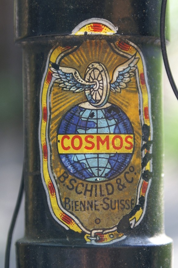 Cosmos-Logo mit geflügeltem Rad und Globus.