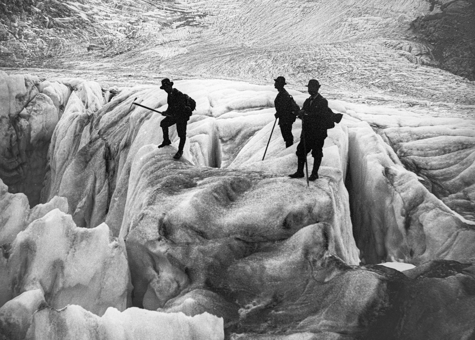 Drei Bergsteiger durchqueren ohne Seil ein Gletscherfeld mit tiefen Gletscherspalten, Schweiz, undatierte Aufnahme um 1910. (KEYSTONE/PHOTOPRESS-ARCHIV/Str)