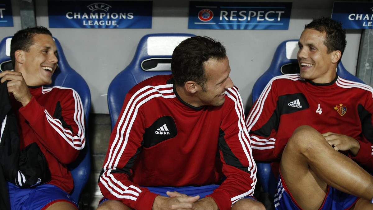 Basel's Marco Streller, center, sits on the bench between Philipp Degen, right, and David Degen, left, during a Champions League play-off second leg match between Switzerland's FC Basel 1893 ...