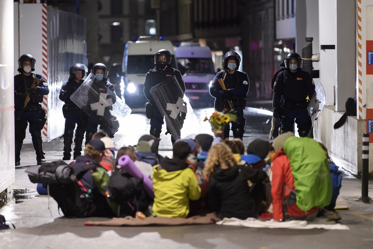 epa08689561 Police wait before intervening during a climate activists' protest, part of the Rise up for Change week of action, in front of the Swiss parliament building, the Bundeshaus, in Bern,  ...