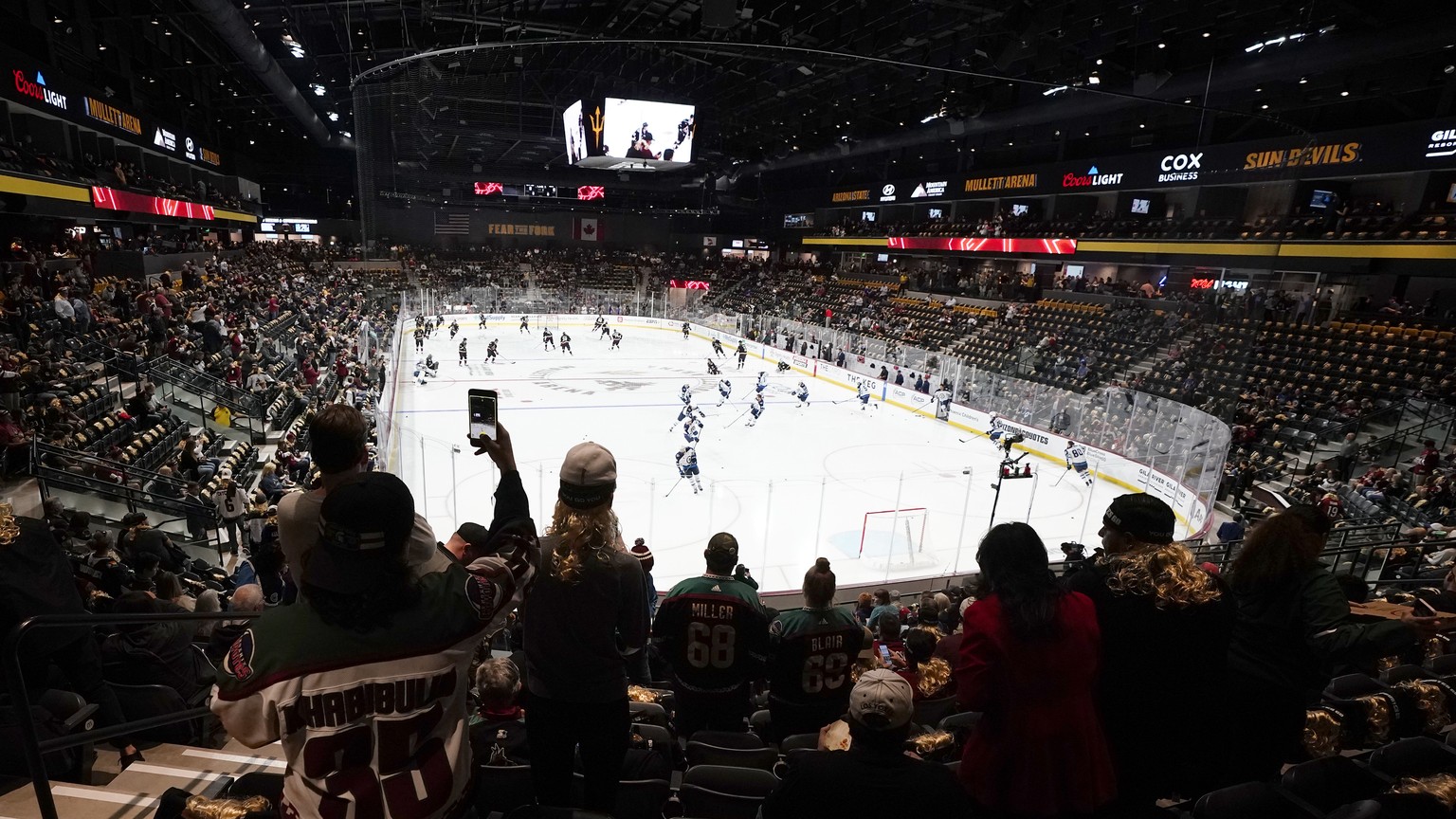 FILE - Fans watch as players warm up prior to the Arizona Coyotes&#039; home-opening NHL hockey game against the Winnipeg Jets at the 5,000-seat Mullett Arena in Tempe, Ariz., Oct. 28, 2022. The Coyot ...