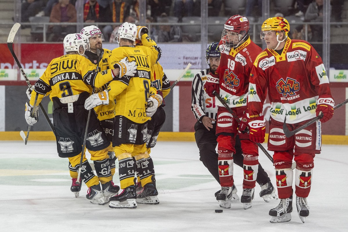 Ajoies Spieler jubeln neben Jonah Neuenschwander (EHCB) und Marcus Sylvegard (EHCB) im Spiel der Eishockey National League zwischen EHC Biel-Bienne, EHCB, und HC Ajoie, HCA, vom Freitag, 16. Oktober 2 ...