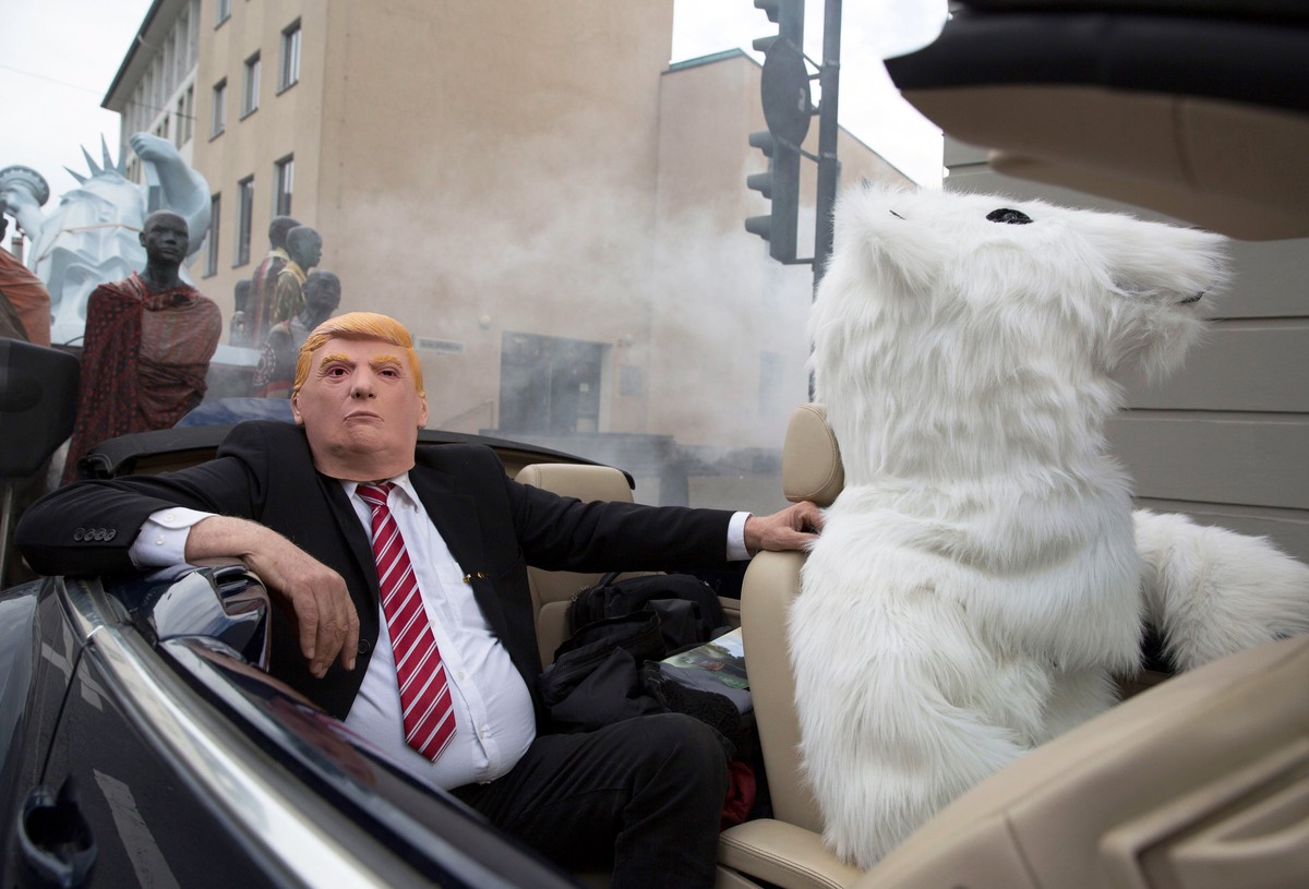 epa06307641 Protesters in costumes of a polar bear (R) and US President Donald J. Trump (L) sit in a convertible car at the 'Climate March' demonstration prior to the UN Climate Change Confe ...