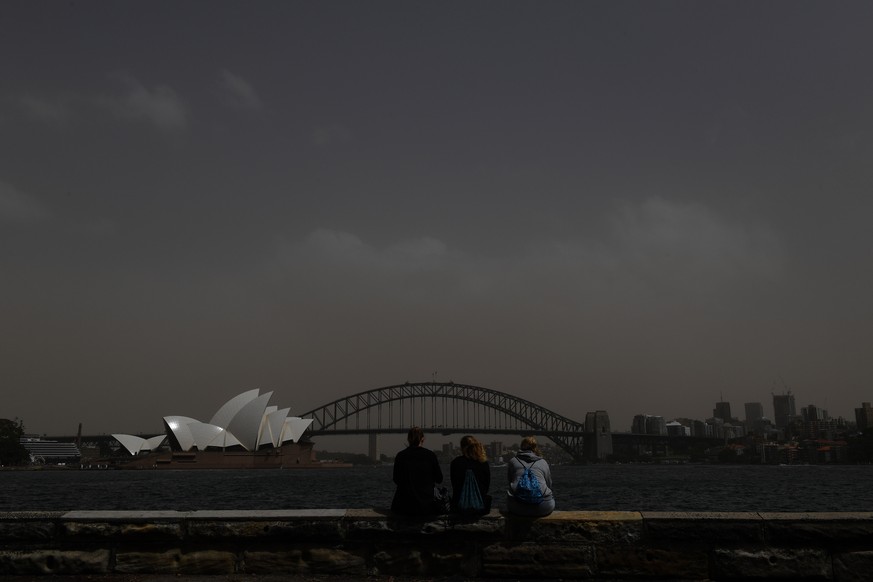 epa07182181 Tourists take photographs against the backdrop of the Sydney Harbour Bridge and the Sydney Opera House as a dust storm descends on Sydney, Australia, 22 November 2018. A dust storm that ha ...