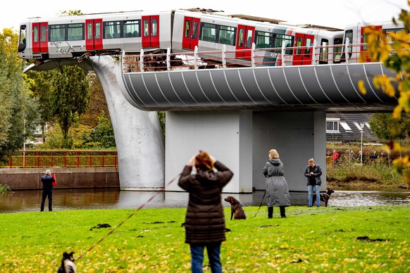 epa08792573 People look at the metro that shot through a stop block at De Akkers metro station in Spijkenisse, The Netherlands, 02 November 2020. There were no passengers on the metro. The driver coul ...