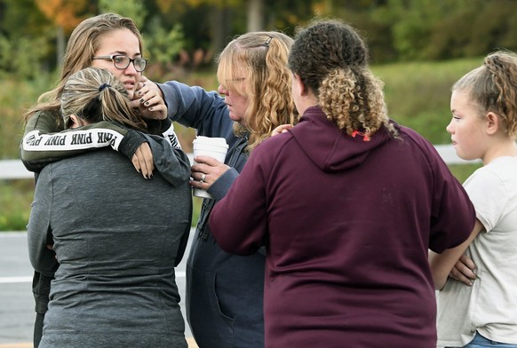 Friends of victims who died in Saturday&#039;s fatal limousine crash comfort each other after placing flowers at the intersection in Schoharie, N.Y., Sunday, Oct. 7, 2018. A limousine loaded with reve ...