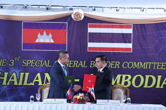 CORRECTS NAME OF THAI DEFENSE MINISTER - In this photo released by Agence Kampuchea Press (AKP), Cambodian Defense Minister Tea Seiha, left, stands with Thai Defense Minister Nattaphon Narkphanit, rig ...