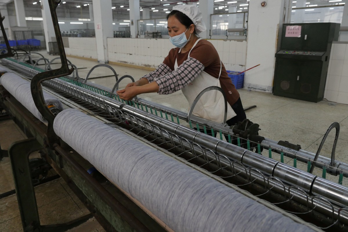 A worker disentangles wool yarn at a spinning machine at a factory owned by Hong Kong's Novetex Textiles Limited in Zhuhai City, Guangdong Province, China December 13, 2016. Picture taken Decembe ...